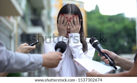 Ashamed businesswoman closing face with hands on press conference, scandal