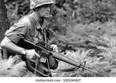 Ashdown Forest Kent UK 1998. An Unidentified Reenactor Of The Vietnam War Walks In A Wood Dressed In The Uniform Of A US Rifleman Holding An M16 Rifle At A Re-enactment Of The Battle Of Dewey Canyon. 