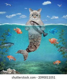 An ashen cat mermaid with a silver fish tail caught a trout in underwater on the seabed.