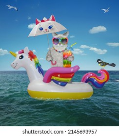 An ashen caticorn in sunglasses drinks a rainbow cocktail on an inflatable ring under an umbrella in the open sea. - Shutterstock ID 2145693957