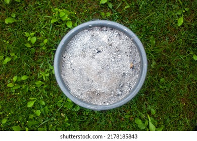 ashes in a bucket on a grassy lawn