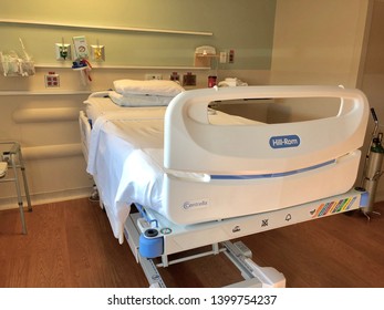 Asheville, NC / USA - May 14, 2019: An Empty Hospital Bed In An Empty Room Equipped With Medical Equipment. Shows The Base Of The Bed As Well As Partial Room.