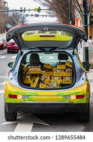 ASHEVILLE, NC, USA-1/18/19: A Colorful SUV Hatch Is Open, Showing A Load Of Yerba Mate, A Branded Drink.