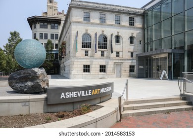 ASHEVILLE, NC, USA-22 JULY 2021: The Asheville Art Museum, showing building entrance, public space, sign, and glass ball and rock sculpture.