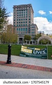 Asheville, North Carolina - 18 April 2020: Sign hangs from the barricade that keeps residents from using public park area in front of county court house.