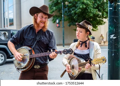 Asheville, North Carolina USA - October 12, 2013: Young street performers playing country music with a banjo and guitar in the historic downtown district of this small southern town.