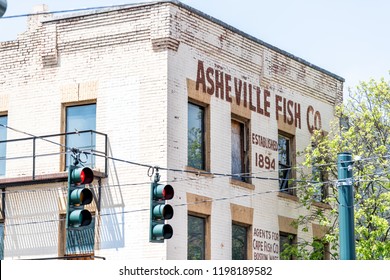 Asheville, USA - April 19, 2018: Downtown old town historic street in North Carolina NC famous town, city in the mountains with sign for fish company market on brick wall of building