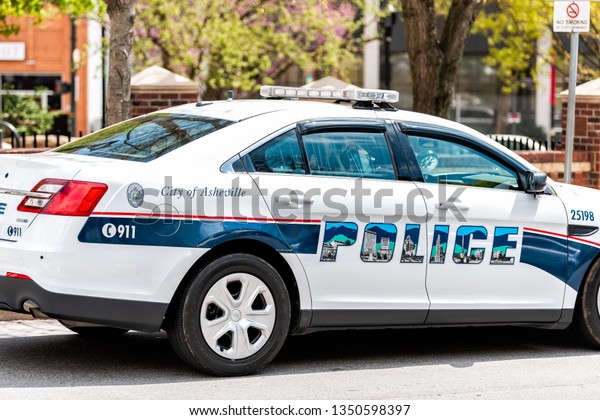 Asheville,\
USA - April 19, 2018: Police law enforcement modern car in North\
Carolina city parked on street road in\
summer