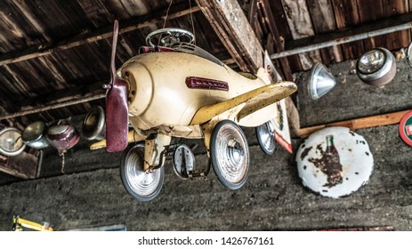 Ashgrove, MO/USA - June 7, 2018: Rustic Antique Pedal Plane Hanging From Rafters In Old Garage At Gary's Gay Parita Along Historic Rt 66 