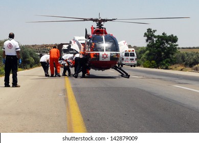ASHKELON, ISR - JUNE 10 2008:Air ambulance rescue helicopter team evacuate injures after a deadly road car accident.The first air ambulance service originated in Australia during 1928.
