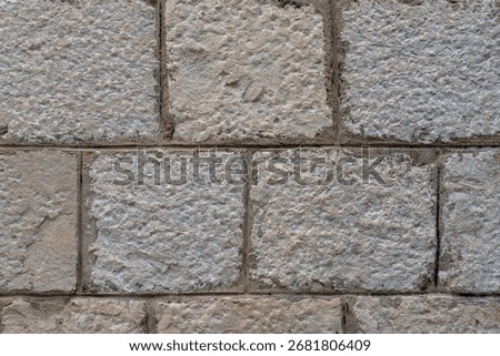 Ashlar limestone wall texture with rock-faced blocks and mortar joints