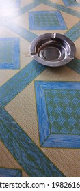 An Ashtray Above The Table That Mixed With The Pattern Of Tablecloth