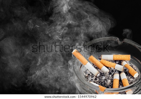 Ashtray and smoked cigarettes on backgrouund