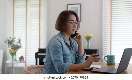 Asia Adult People Or SME Owner Woman Leader Moody Sitting Tired Busy Phone Call Work On Laptop Computer At Desk House Office Think Worry Concern Give Advice On Distance Job Crisis Corporate Trouble.