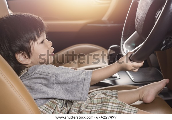 Asia Baby Boy have Fun Driving  in Luxury\
Car Which dream to drive a car in the\
future.