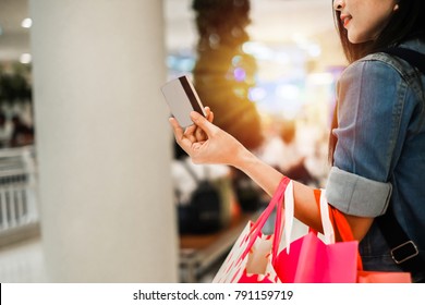 Asia Beautiful Woman Carrying Shopping Bag Holding Credit Card And Walking In The Department Store.young Lady Shopping By Using Credit Card On Weekend.