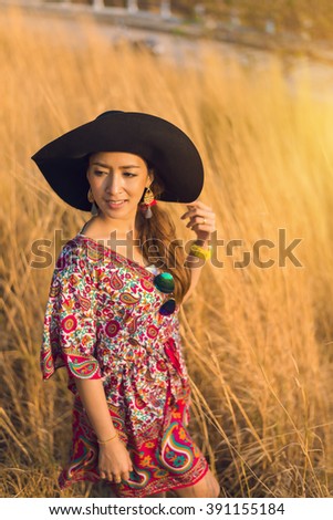 Asia beautiful Woman in Golden meadow. travel and sunset in vintage style