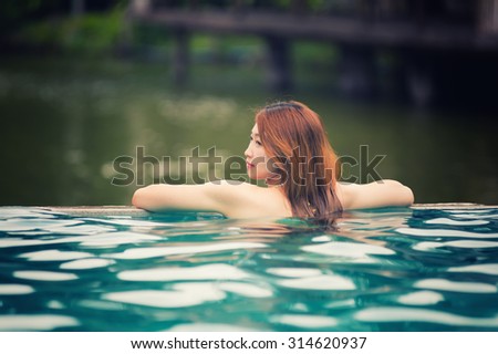 Asia beautiful woman relaxing on swimming pool