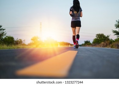 Asia beautiful woman in sport ware running on the road.exercise concept. - Shutterstock ID 1323277244