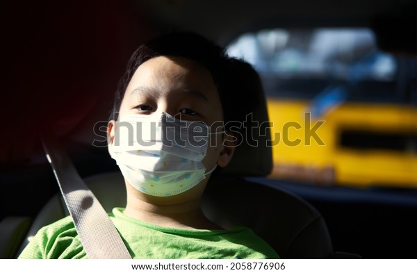 asia boy wear protect mask for covid-19 in car
cabin while travel