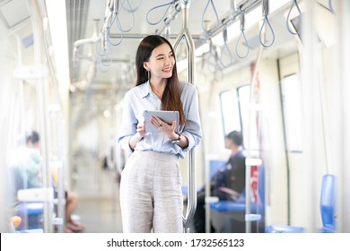 Asia Business Woman Going To Work And  And Playing Mobile Phone  In Monorail Subway Station.