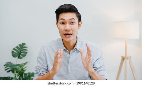 Asia businessman social distancing in new normal situation for virus prevention looking at camera presentation to colleague about plan in video call while work in office. Lifestyle after corona virus. - Shutterstock ID 1991148128