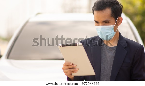 Asia businessman wear medical\
mask protect covid19 coronavirus and outdoor tablet\
technology