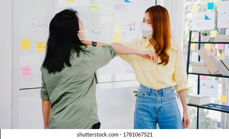 Asia Businesspeople Greeting With Elbow Bump And Wear Medical Face Mask For Social Distancing In New Normal Situation For Virus Prevention Back At Work In Office. Lifestyle And Work After Coronavirus.