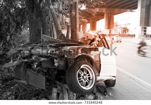 Asia car accident critical, car crashes in to\
tree and electric pole on sidewalk. Car crash in Asia with light\
effect for background.