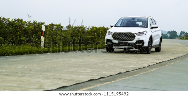 Asia, China, Chongqing - June 25, 2017: Tester of\
Junma Motor is testing the new white suv car in Chongqing\'s\
production base
