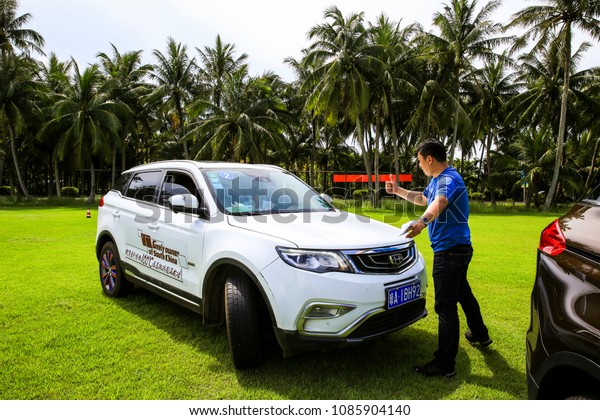 Asia,\
China, Hainan - June 9, 2017: Car media reviewer is explaining the\
newly-listed Geely Bo Yue SUV, recording\
video