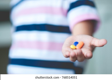 Asia Cute Little Girl Having Sick And Happy To Take Medicine In Hand. Asian Adorable Kid Female Needle Eating Three Drugs Of Pill . Concept Child And Drug.