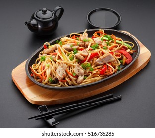 Asia food. Udon noodles with chicken on the black table.