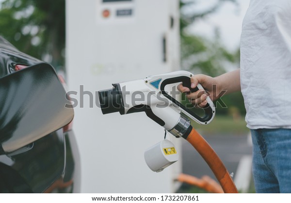 asia girl charging\
electromobile in city
