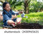 Asia girl  gardener watering can water of young green plants at nature park for reduce global warming earth. Ecology Concept 