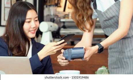 Asia Girl Make Digital Payment, Young Asian Woman Holding Smart Phone For Paying Contactless At Coffee Shop, Cafe Background, Small Business Financial And Contactless Payment Concept