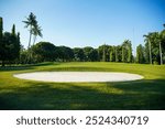 Asia golf course sand pit bunker. Royale Krakatau Golf, Cilegon, Banten, Indonesia. Tropical golf course. Golfer, grass, coconut trees, playing, field, landscape.