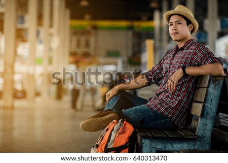 Asia handsome man traveler with backpack at the bus station with a traveler. Travel concept.