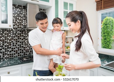 Asia , Happy Young Family With Mum, Dad And Young Children Cooking In The Kitchen Preparing A Spaghetti Meal Together