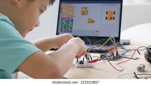 Asia home school young small kid happy smile self study online lesson excited make AI circuit toy. STEM STEAM digital scratch class on laptop screen for active children play arduino enjoy fun hobby. - Shutterstock ID 2153153857