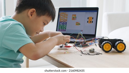 Asia home school young small kid happy smile self study online lesson excited make AI circuit toy. STEM STEAM digital scratch class on laptop screen for active children play arduino enjoy fun hobby. - Powered by Shutterstock