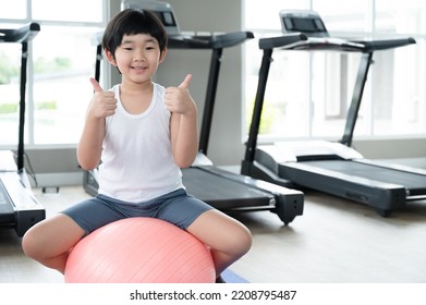 Asia Kid Boy Exercise With Exercise Ball At Fitness Gym