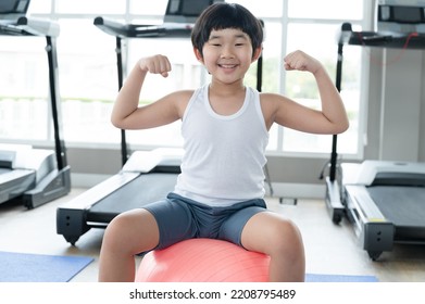 Asia Kid Boy Exercise With Exercise Ball At Fitness Gym