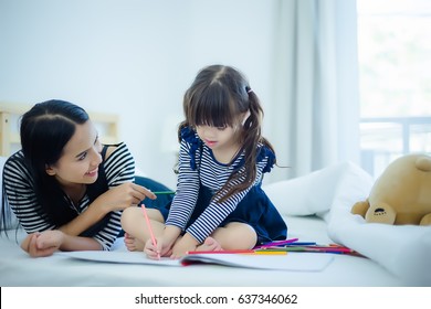 Asia kids happy loving family. pretty young mother reading a book to her daughters - Shutterstock ID 637346062