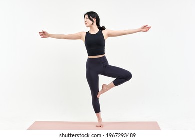 Asia Korean Girl Long Haired Beautiful Pilates Or Yoga Athlete Does A Graceful Pose While Wearing A Tight Sports Outfit Against A White Background In A Studio