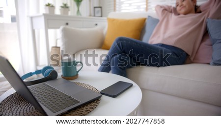 Asia lady people sitting easy hand behind head work at sofa cozy home lying down close cellphone with calm day dream. Tired life time to log out, leave health care issue, stop turn off social media. [[stock_photo]] © 