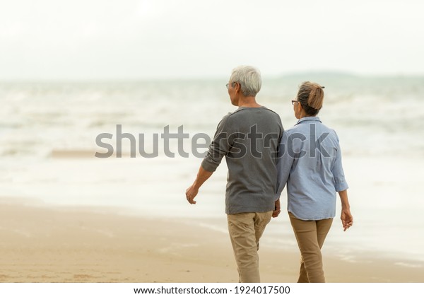 Asia Lifestyle senior couple walking chill on the
beach happy in love romantic and relax time.  People tourism
elderly family travel leisure and activity after retirement in
vacations and summer.