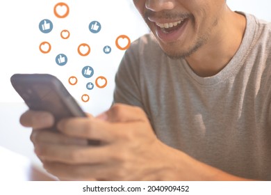 Asia Man Look At Smart Phone And Smile For Like And Love Emotion. Social Media Using On Smartphone To Get Like And Love To Engage With Target Customer In Marketing Campaign.