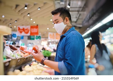 Asia Man Wearing Surgical Mask Walking In Supermarket For Buying Some Fresh Fruit.