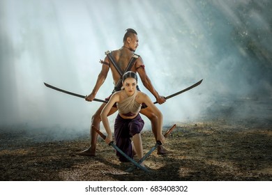 Asia Man And Woman In Military Dress Ancient Of Thailand And Hand Holding A Sword Ready To Fight.